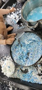 Child exploring snowflake soup messy play tray